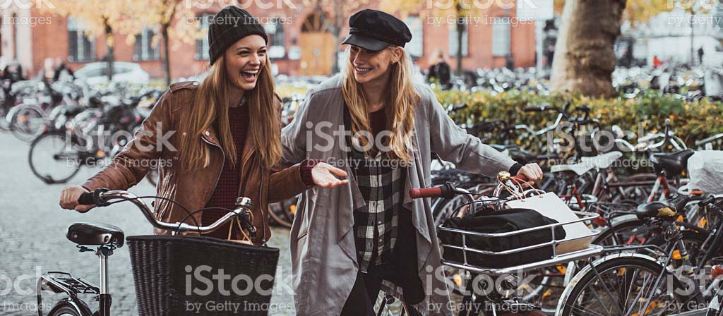 two women walking with bikes