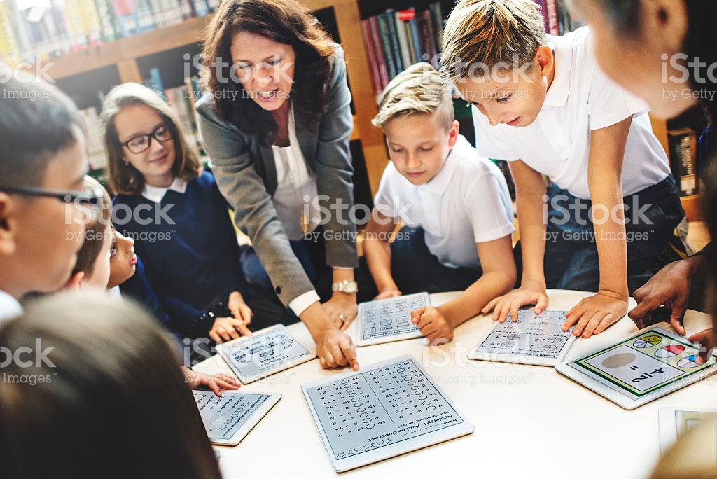 teacher and students looking at tablets