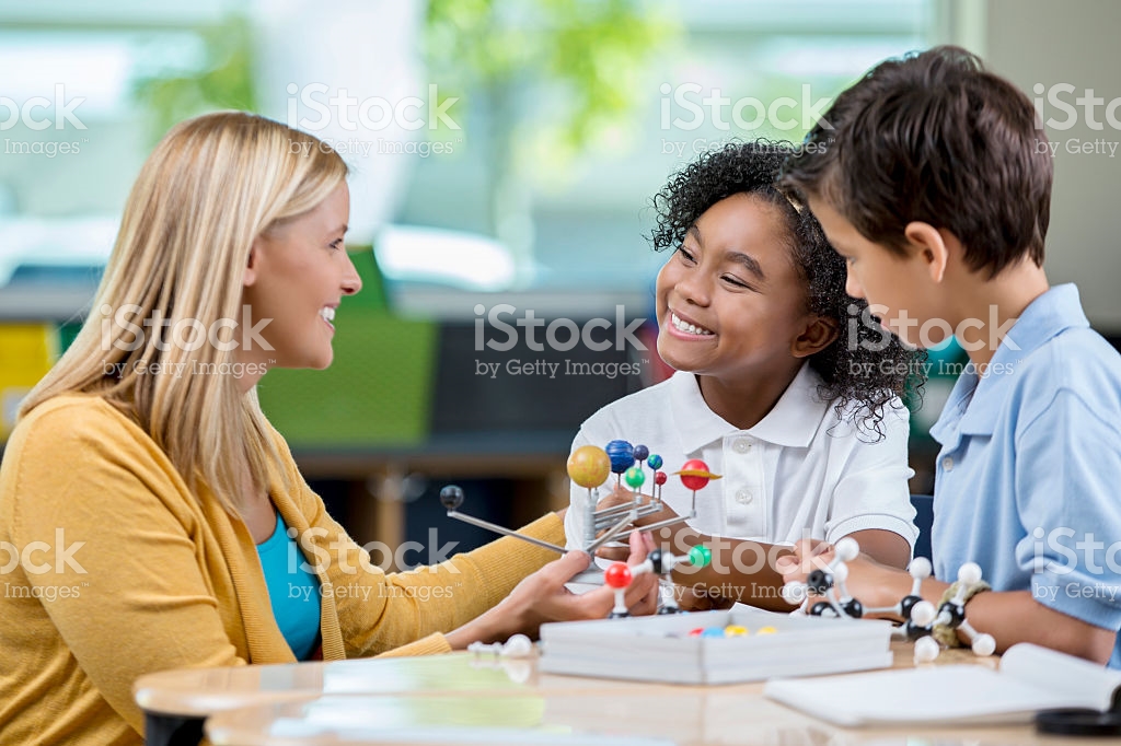 teacher and two kids looking at the solar system