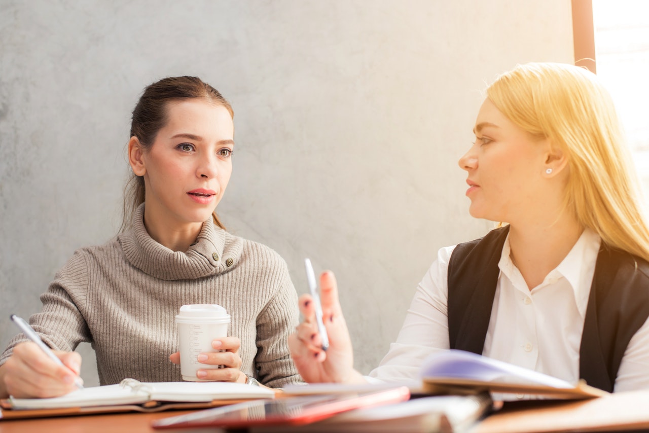 Two women writing and discussing